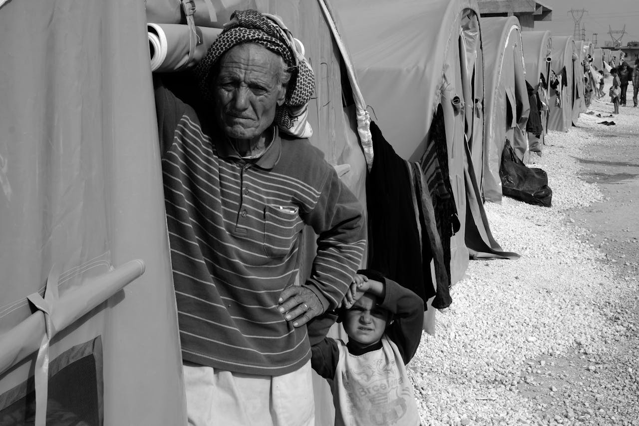 services-01 Black and white image of refugees in a camp, highlighting humanity and resilience.
